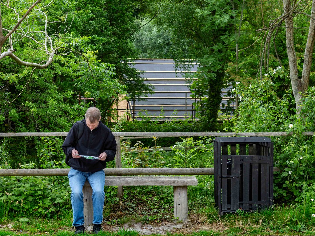 Man sitting on bench studying map