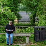 Man sitting on bench studying map
